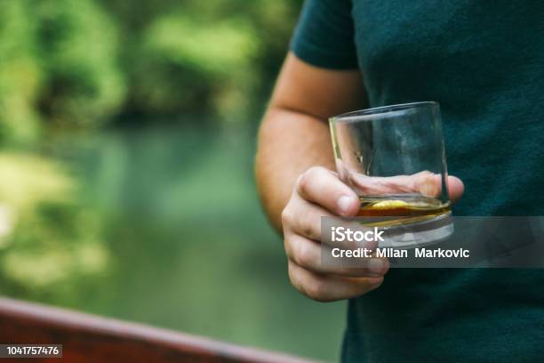 Holding Glass With Whiskey And Smoking Cigar Stock Photo - Download Image Now - 30-34 Years, Adult, Adults Only