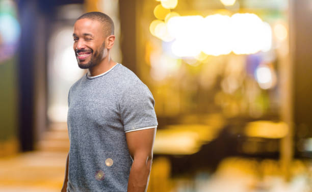 istock African american man with beard blinking eyes with happy gesture 1041761370