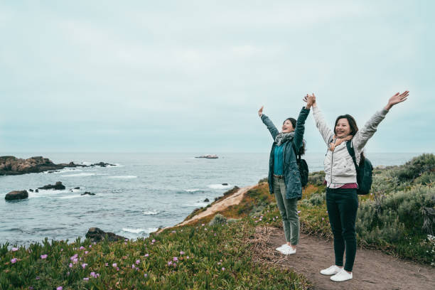 istock friends raising arms standing on the coast 1041762800