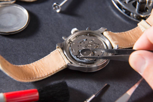 detalhe da obra de um relojoeiro que substitui uma bateria - watch maker work tool watch equipment - fotografias e filmes do acervo