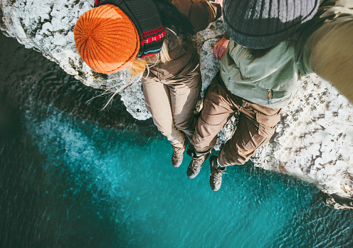Couple in love Man and Woman sitting together above sea on cliff Travel happy emotions Lifestyle concept. Young family traveling romantic vacations autumn winter season aerial view