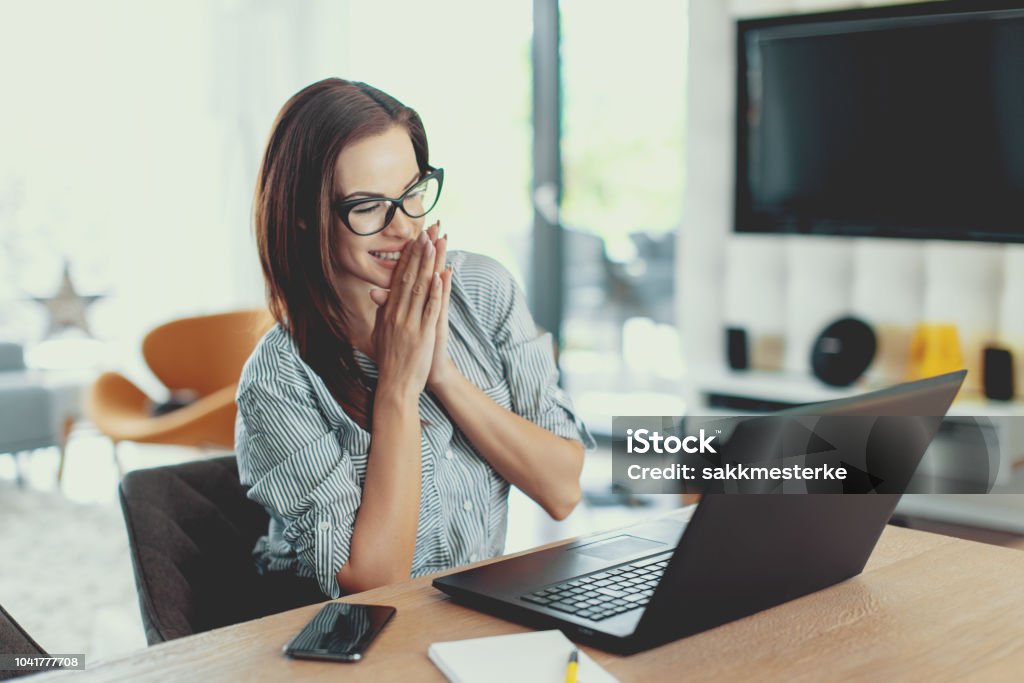 Happy young modern businesswoman reading good news on laptop Happy young modern businesswoman reading good news on laptop indoors Applying Stock Photo