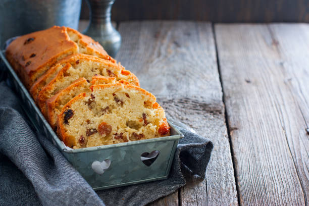 petit gâteau avec des raisins secs dans un support en métal sur une table en bois. mise au point sélective - gâteau aux fruits photos et images de collection