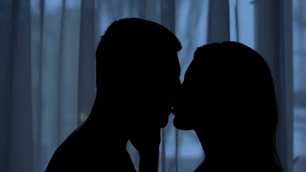 silhouette fidanzato e fidanzata che si baciano al buio, affetto, sensazione d'amore - passion people love sensuality foto e immagini stock