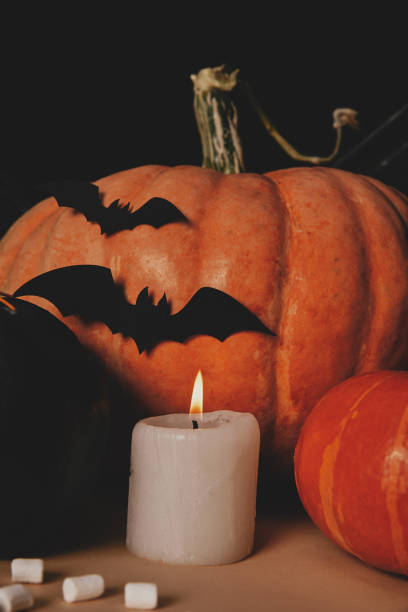 istock pumpkins, candle, marshmallows and paper bats on table, halloween concept 1041790940