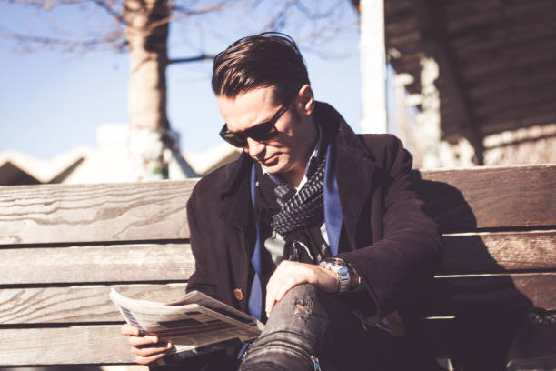 istock Businessman reading newspaper while relaxing on bench. 1041791036