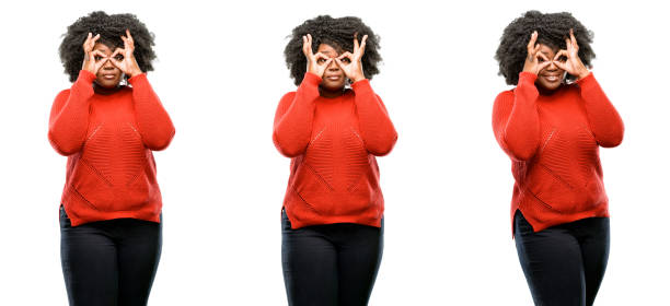 istock looking at camera through her fingers in ok gesture. Imitating binoculars 1041796370