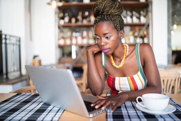 istock African woman drinking coffee and using laptop in cafeteria 1041796664