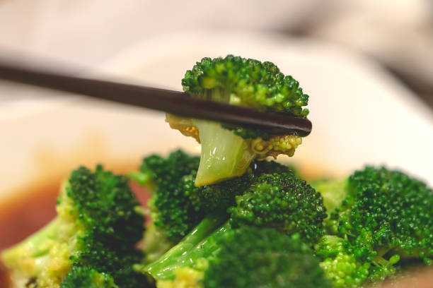 istock Chopstick picking up Chinese style fried broccoli 1041801730
