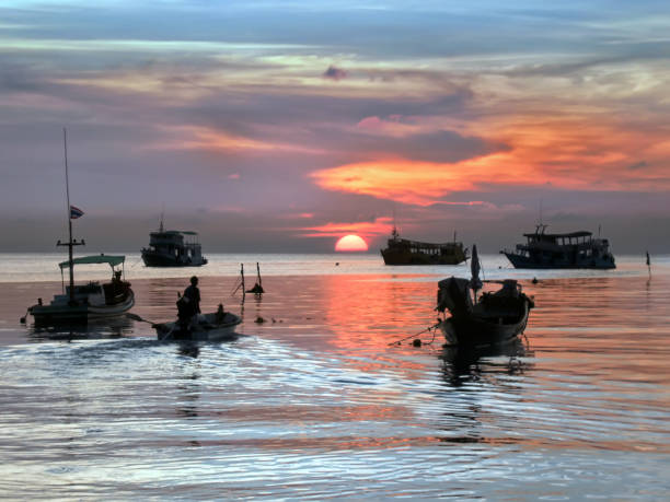 istock Sunset with boats on tropical beach 1041809488