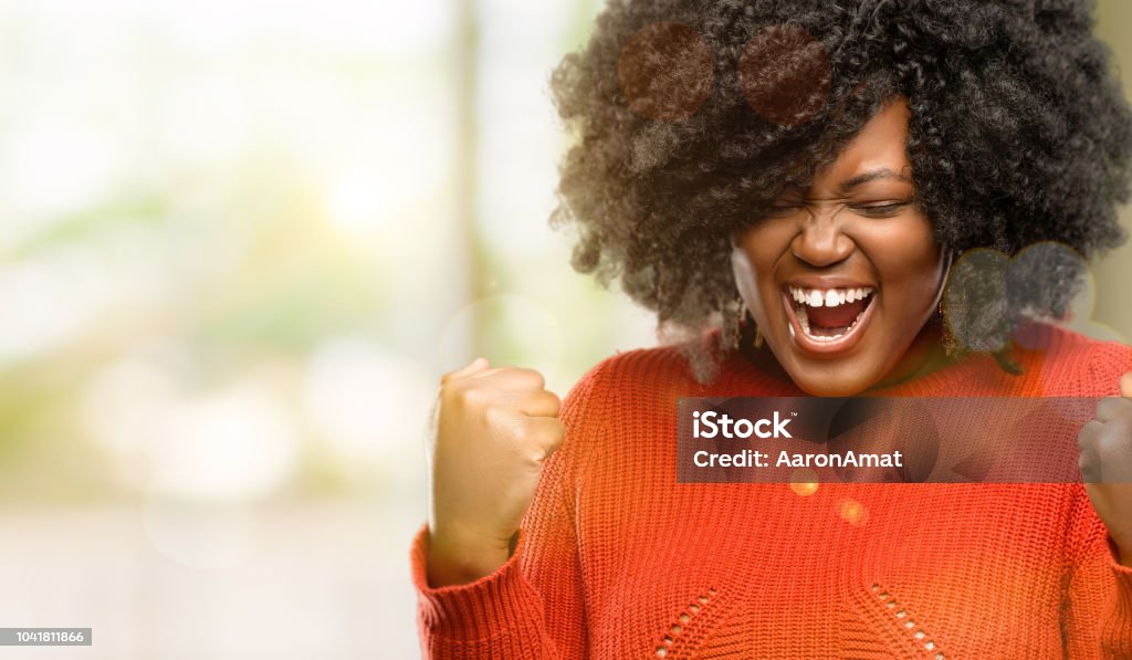 happy and excited celebrating victory expressing big success, power, energy and positive emotions. Celebrates new job joyful Beautiful african woman happy and excited celebrating victory expressing big success, power, energy and positive emotions. Celebrates new job joyful, outdoor Women Stock Photo