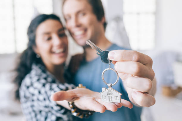 propriétaires de maison gais couple maintenant une touche enfoncée - clé de maison photos et images de collection