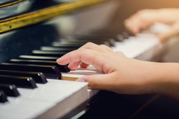 istock Boy play the piano with selective focus to piano key and hands. 1041817374