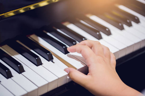 istock Boy play the piano with selective focus to piano key and hands. 1041817706