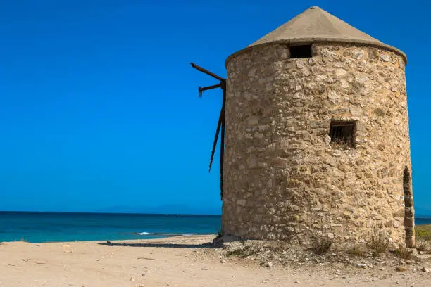 The old windmill is located on Gira beach, Lefkada Island, Greece