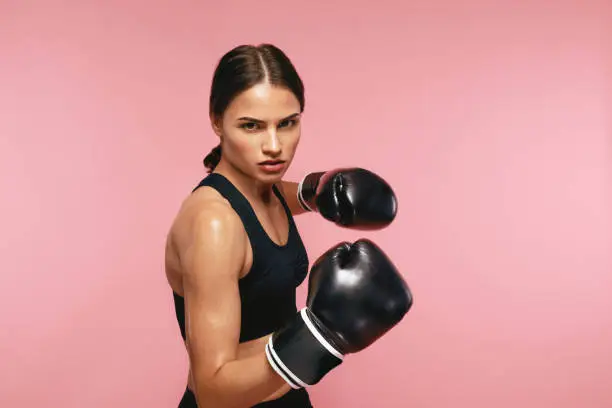 Woman Boxer In Gloves Training On Pink Background. Portrait Of Sports Female Boxing. High Resolution