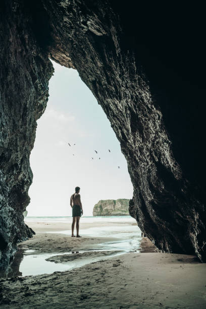 istock Silhouette Man Seem Through Cave At Beach 1041822164