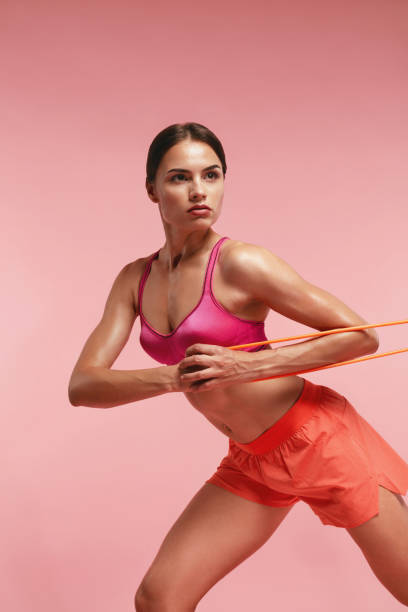 istock Workout. Woman Training With Resistance Bands On Pink Background 1041822422