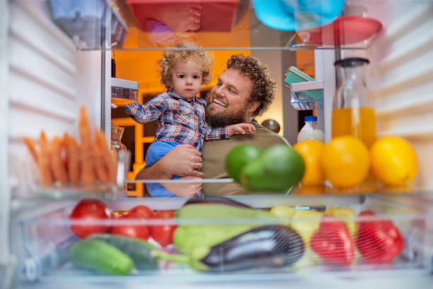 istock Father and son standing in front of opened fridge. 1041822608