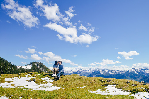Young Asian couple kiss on high mountain, Schafberg mountain (the mountain in movie 'sound of music'), Austria