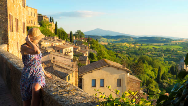 montepulciano, toscana, italia, chica mira el paisaje de la ciudad y el campo desde el balcón - urban scene women adventure city fotografías e imágenes de stock