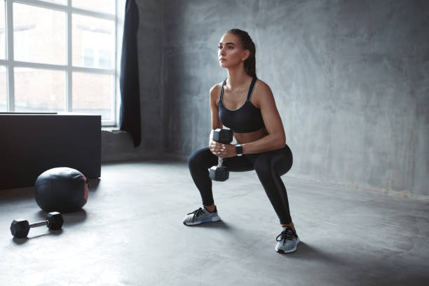 formação. mulher de esportes em moda sportswear fazendo agachamentos - crouching - fotografias e filmes do acervo