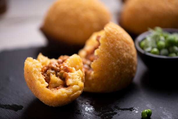deliziosa palla di riso su tavolo nero - arancini siciliani foto e immagini stock