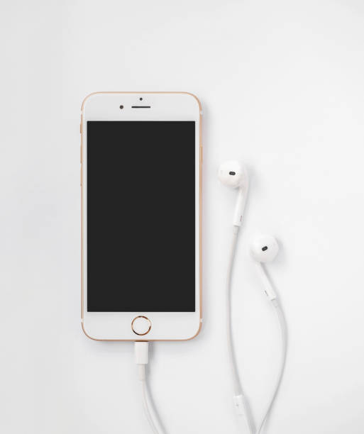 Apple iPhone 7 mockup and Apple EarPods CHIANGRAI, THAILAND -SEPTEMBER 9, 2016: Close-up image of new Apple iPhone 7 mockup connect with charging cable (Lightning) and Apple EarPods on white background headphones plugged in photos stock pictures, royalty-free photos & images
