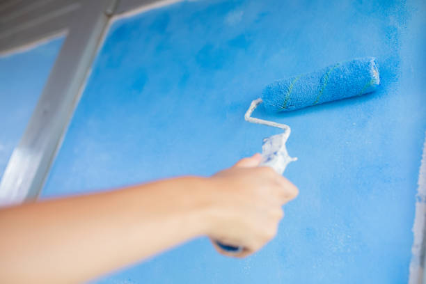 istock Young girl painting wall with paint roller 1041845804