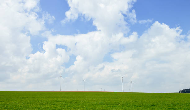 istock Wind power mill on green meadow under blue sky 1041847042