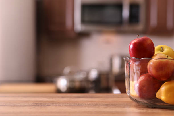 istock Defocused kitchen with apples in bowl on wooden table. 1041853622