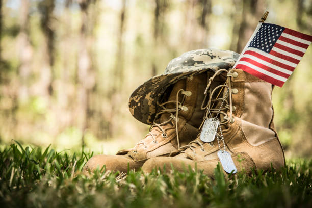 USA Military boots, hat, flag, and dog tags outdoors. USA military boots, hat, flag and dog tags in outdoor yard. No people in this Memorial Day or Veteran's Day image. usa flag shoes stock pictures, royalty-free photos & images