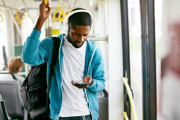 Man Using Phone, Listening Music Traveling In Train Man Using Phone, Listening Music Traveling In Train. Black Male Student With Headphones Riding In Public Transport. High Resolution city of mobile stock pictures, royalty-free photos & images