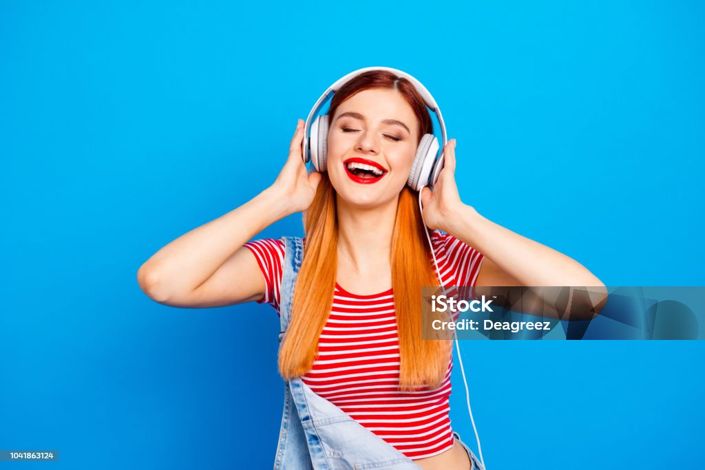 My favorite track! Close up photo portrait of positive optimistic with beaming toothy smile long hairstyle wearing white headset girl isolated bright vivid background Music Stock Photo