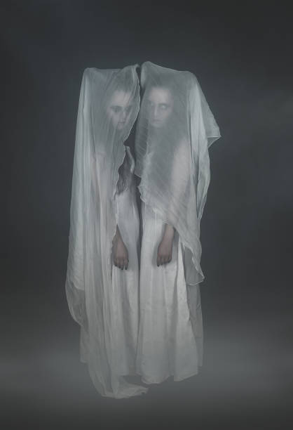 istock Two sad ghosts in cerement on dark 1041868778