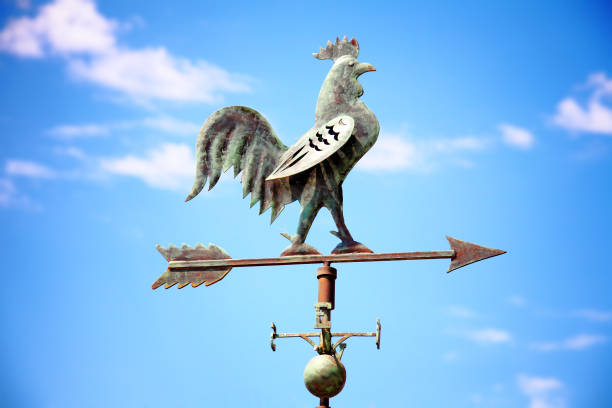 Weather vane with the image of a cock Weather vane with the image of a cock against the background of the blue sky mistral wind stock pictures, royalty-free photos & images
