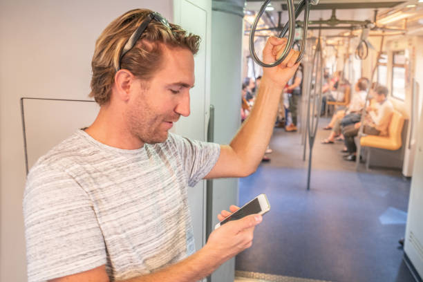 istock Young man in subway using smart phone text messaging on mobile device in Bangkok metro, Asia. People travel business using technology in public transportation, commuters. 1041880444