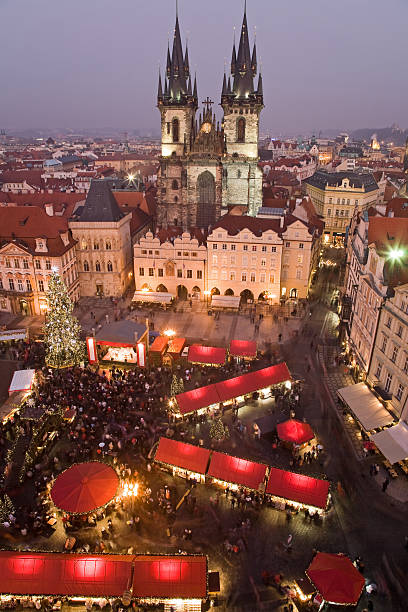 A high view of a Christmas market in Prague Sunset on Old Town Square with St. Teyn gothic cathedral in Prague during Christmas market. prague christmas market stock pictures, royalty-free photos & images