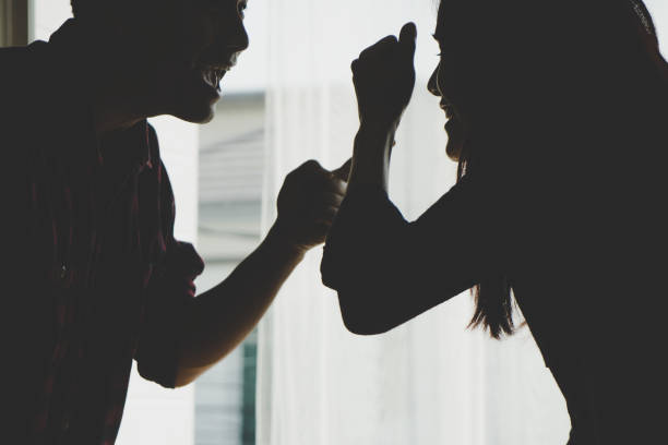 Silhouette Asian couple is fighting by the windows stock photo