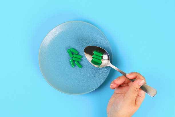 istock Eating pills as a regular meal. Pills on a plate on a blue table background. Top view, copy space, flat lay. 1041897532