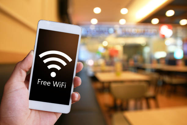 istock Man is holding a white generic smartphone showing free WiFi. 1041925770