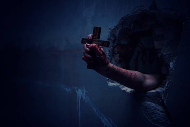 istock Horror Scene with Bloody Hand is holding a holy cross. 1041929512