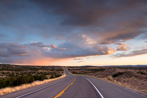Carretera curva en una espectacular puesta de sol bajo nubes hermosas del desierto photo
