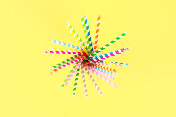 istock Multi-colored straw paper tubes on a bright yellow pastel background. Top view, copy space. 1041934408