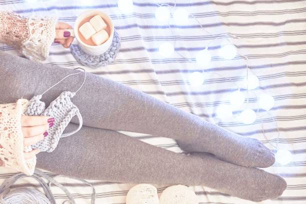 istock A woman on the bed knits a scarf. 1041935864