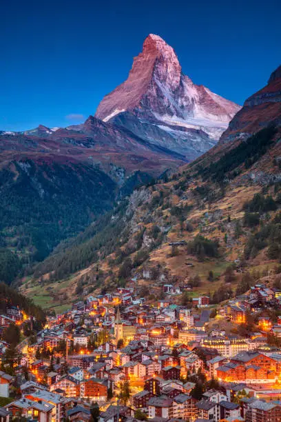 Image of iconic village of Zermatt, Switzerland with Matterhorn in the background during twilight.