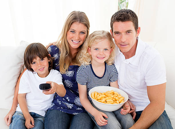 istock Loving family watching television sitting on sofa 104194983