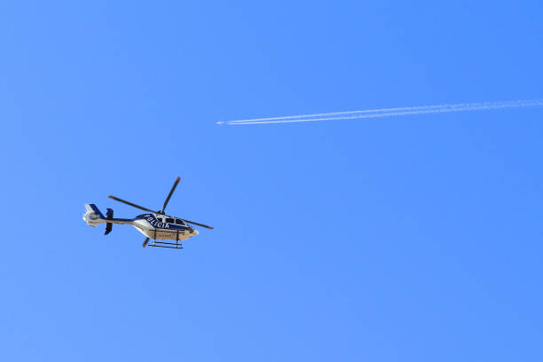 POLCE HELICOPTER FLYING BELOW ONE AIRLINER