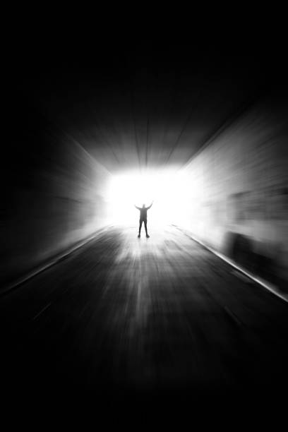 silhouette d’une femme à la fin d’un tunnel - spirituality light tunnel light at the end of the tunnel photos et images de collection