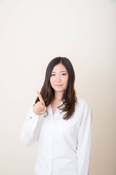 istock asian woman pointing with index finger 1041967414